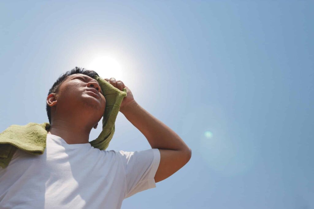Worker experiencing heat exhaustion that can lead to workers comp