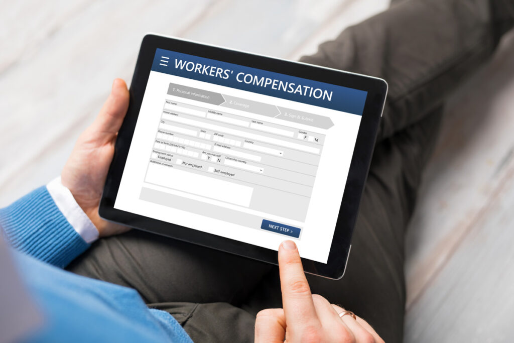 A person filling out a workers’ compensation form on a tablet.