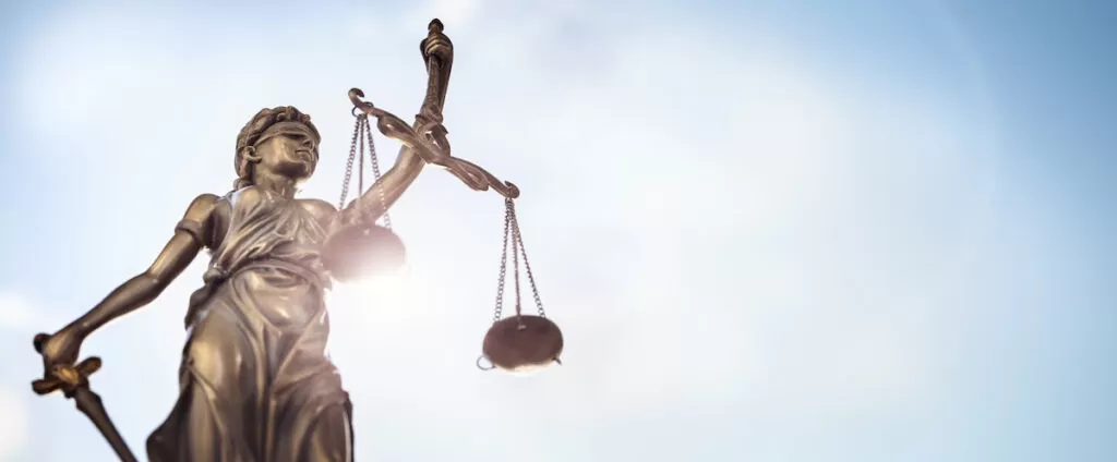 Legal and law concept statue of Lady Justice with scales of justice and sky background